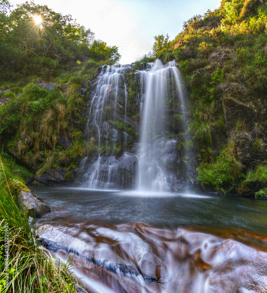 Water flows over the rocks under a waterfall Water flows over the rocks under a waterfall