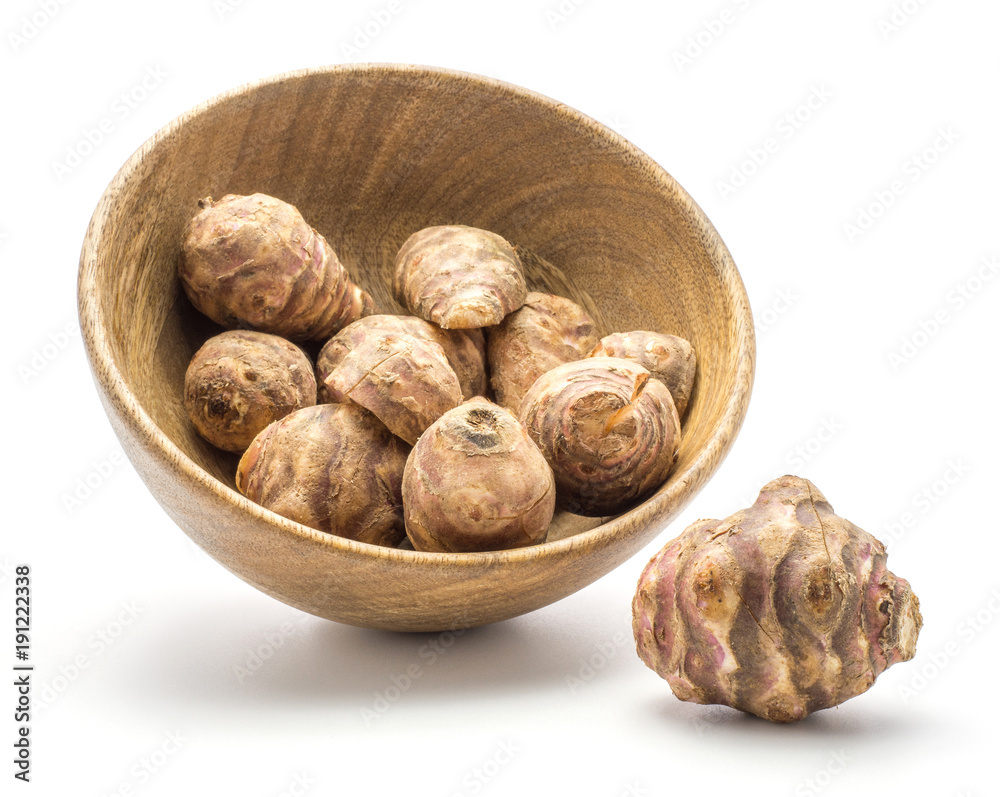Jerusalem artichoke tubers in a wooden bowl isolated on white background sweet crisp topinambur. Jerusalem artichoke tubers in a wooden bowl isolated on white background sweet crisp topinambur.