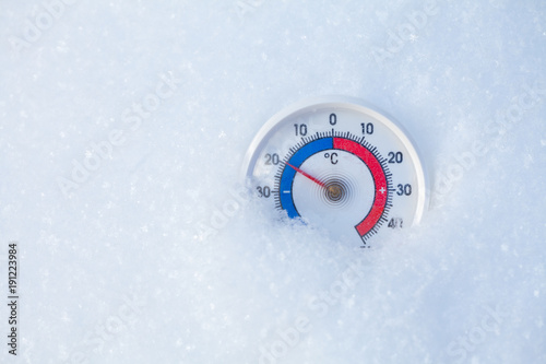 Outdoor thermometer in snow shows minus 20 Celsius degree cold winter weather concept