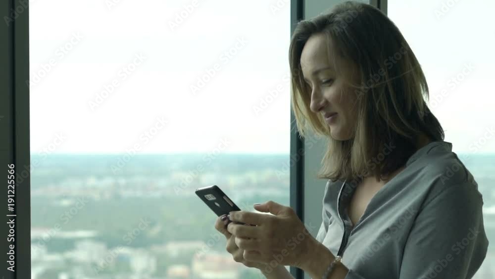 Young businesswoman texting on smartphone by window in office
Young businesswoman texting on smartphone by window in office