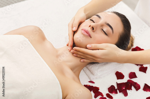 Woman getting professional facial massage at beauty salon