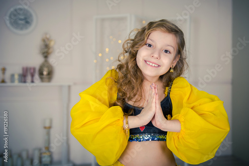 dancer girl. Girl  closing with a yellow Indian handkerchief.  Eastern dance. Portrait of a smiling girl dancer in studio. Dancing teenage girl in a beautiful yellow attire  
