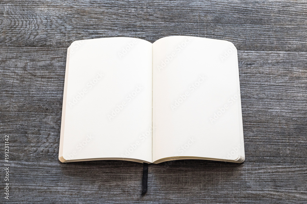 Fototapeta premium Blank open A5 size book, catalog, magazine, brochure, or booklet mock up template paper texture on brown wood table floor