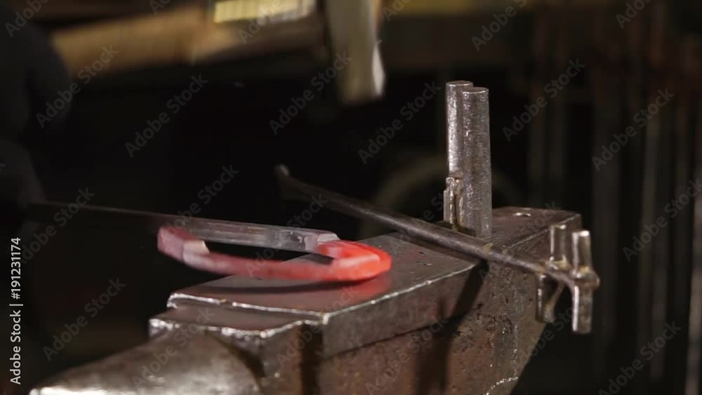 Close up shot of a professional smith working with a metal in a forge. Spark and pieces of metal popping off. Close up shot of a professional smith working with a metal in a forge. Spark and pieces of metal popping off.