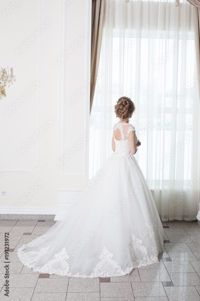 Beautiful bride in wedding dress before wedding ceremony in great hall Beautiful bride in wedding dress before wedding ceremony in great hall