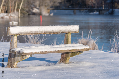 a cold and frozen bench covered in snow in sweden