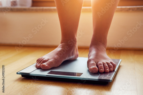 Female bare feet on weight scale photo