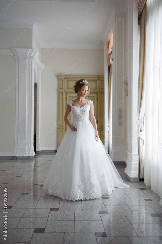 Fototapeta premium Beautiful bride in wedding dress before wedding ceremony in great hall