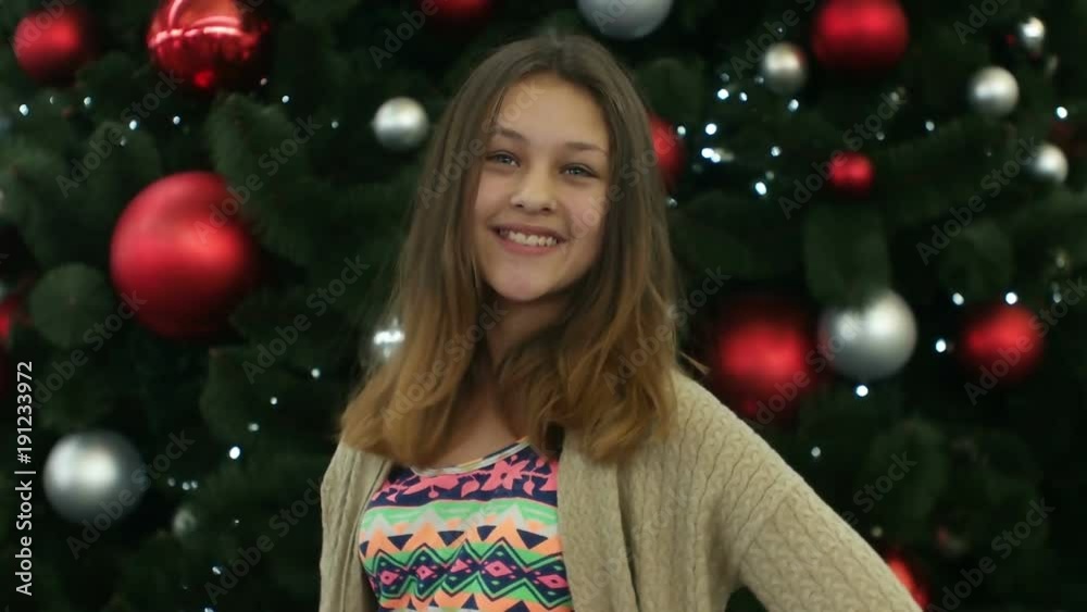 girl teenager smiling near Christmas tree girl teenager smiling near Christmas tree