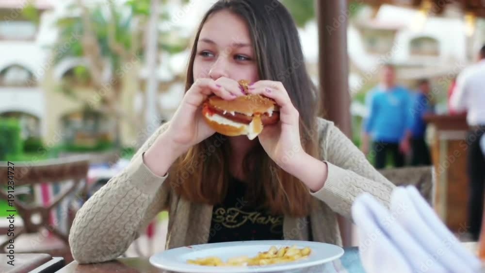 girl eating a hamburger and french fries girl eating a hamburger and french fries
