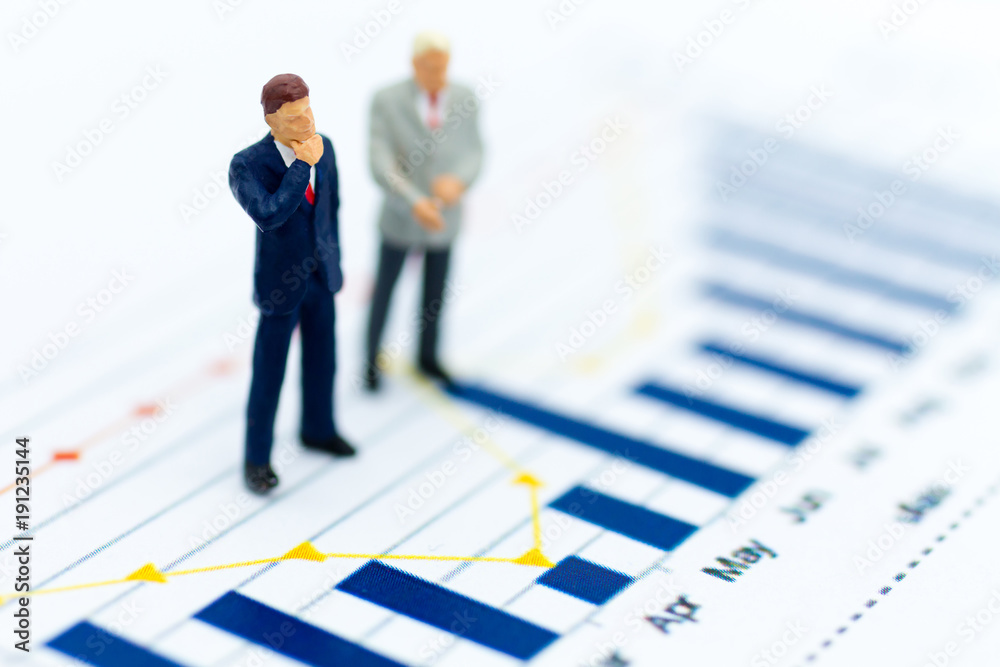 Miniature people: Businessman stand front of dashboard, display graphs, profit margins of background. Image use for business concept. Miniature people: Businessman stand front of dashboard, display graphs, profit margins of background. Image use for business concept.