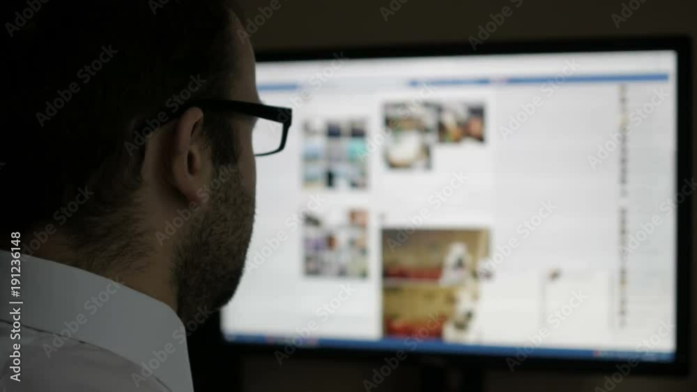 A man using on social networks. Businessman reads the news. Computer monitor showing blur Facebook news feed page young girl online.
