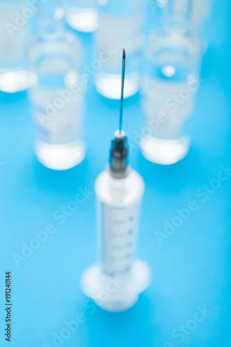 Close-up of a needle of a syringe on a blue background.