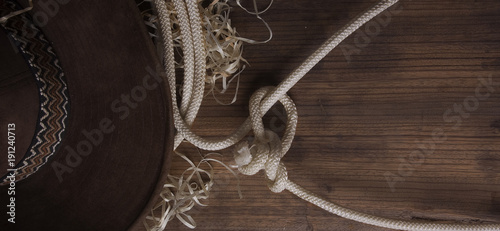 Classical cowboy hat and lasso lie on old boards on the ranch