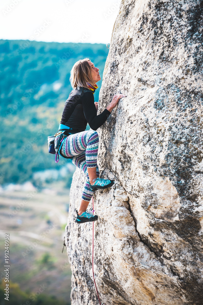 Fototapeta premium Girl climbs the rock.