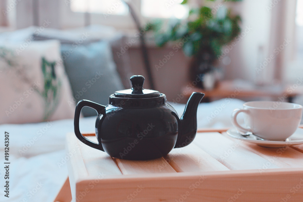 Breakfast in bed. Teapot with tea and mug on the table Breakfast in bed. Teapot with tea and mug on the table