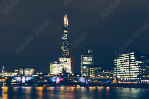 London skyline at night with shard building and reflections on River Thames