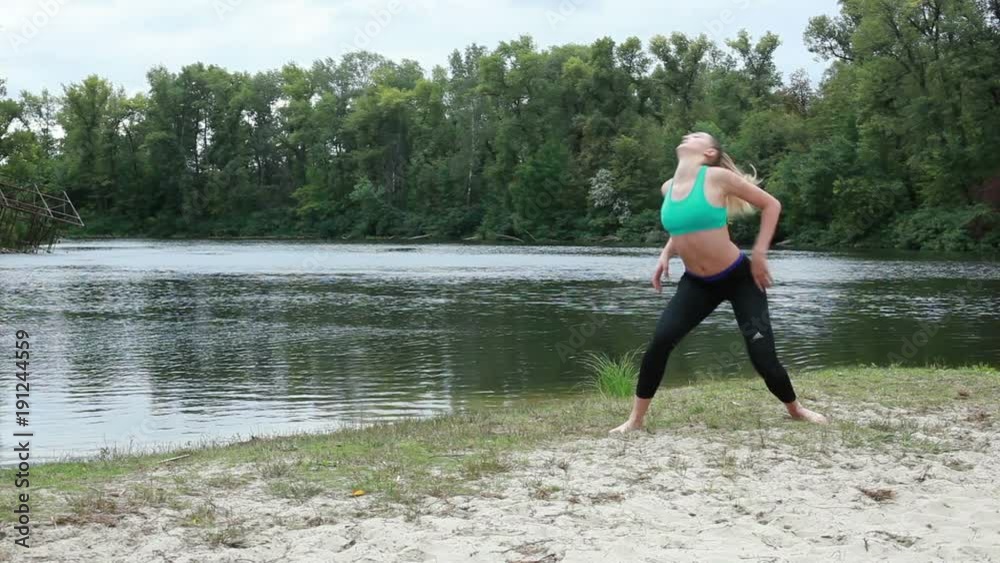 Girl athlete doing exercises on the river bank. Girl athlete doing exercises on the river bank.
