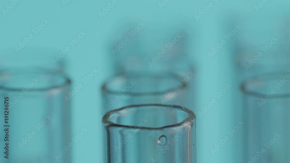 Close up of laboratory scientist working with a pipette analyzes and extract the DNA or molecules in the test tubes.on blue background Close up of laboratory scientist working with a pipette analyzes and extract the DNA or molecules in the test tubes.on blue background