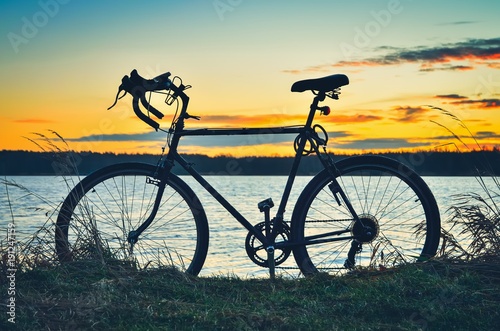 Active sunrise at the lake. Bike in a beautiful colorful scenery.