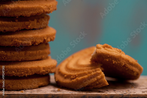 Close up of butter cookies/biscuits on wooden board with teal green rustic background photo