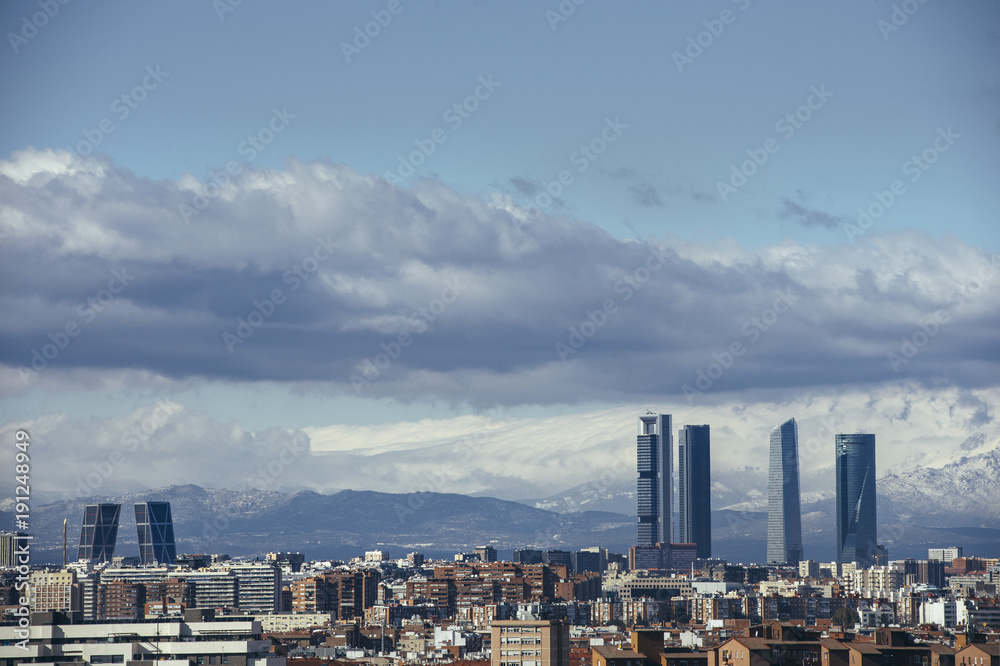Madrid Skyline from the air, snowy in the background mountains
