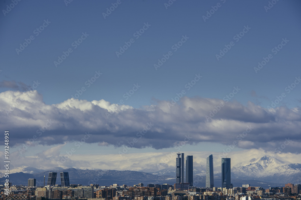 Obraz premium Madrid Skyline from the air, snowy in the background mountains