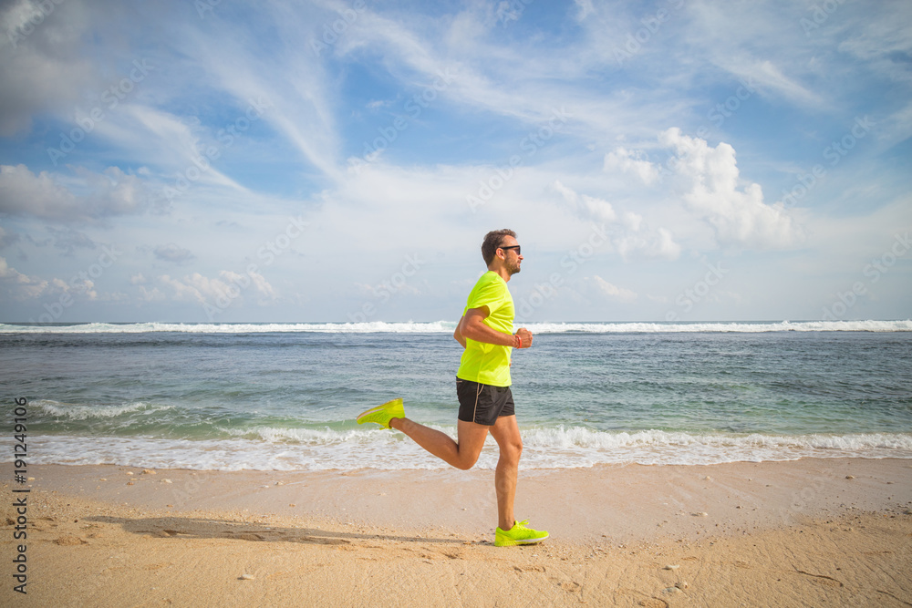 Jogging on a tropical sandy beach near sea / ocean. Jogging on a tropical sandy beach near sea / ocean.