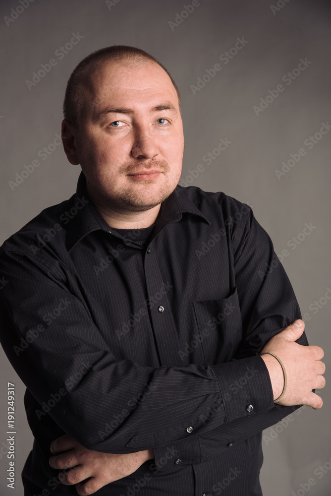 portrait of man in black shirt isolated on gray studio background posing to the camera portrait of man in black shirt isolated on gray studio background posing to the camera