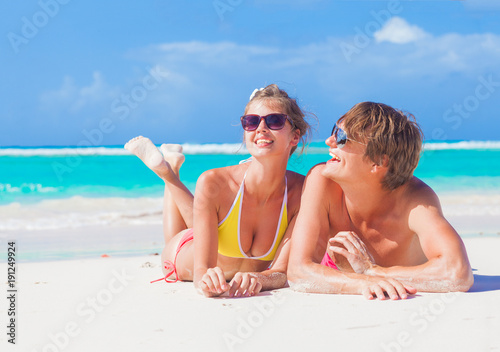 picture of happy couple in sunglasses lying on the beach © el.rudakova