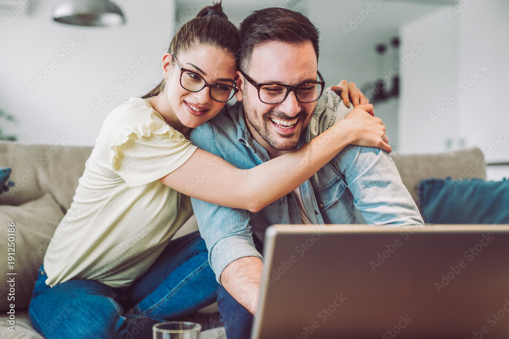 Happy couple with laptop spending time together at home Happy couple with laptop spending time together at home
