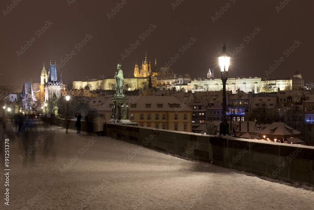 Night snowy Prague Lesser Town with gothic Castle from Charles Bridge and its baroque Statues, Czech republic