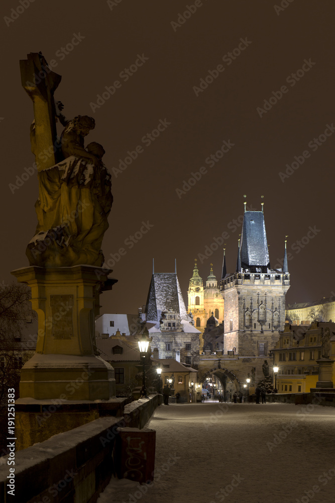 Night snowy Prague Lesser Town with gothic Castle from Charles Bridge and its baroque Statues, Czech republic