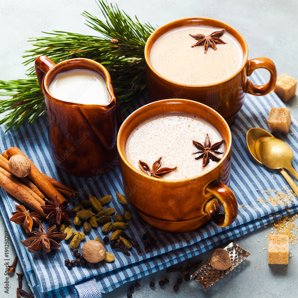 Masala tea chai latte traditional hot Indian teatime ceremony sweet milk with spices, herbs organic infusion healthy beverage in porcelain cup on blue table background