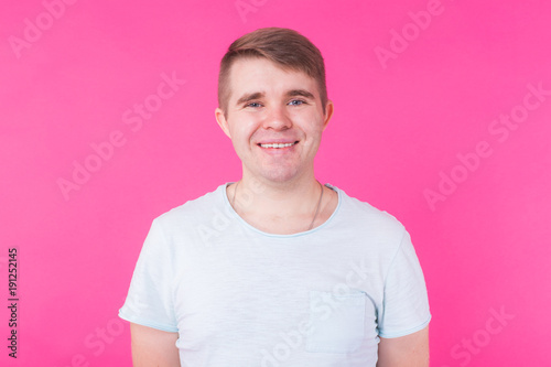 Handsome smiling young man on pink background