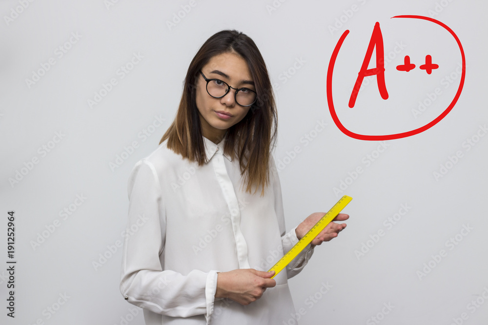 Young and funny strict teacher with glasses shakes ruler in hands on the  grey background with good mark symbol. School or university concept.  Selective focus and shallow DOF Stock Photo | Adobe