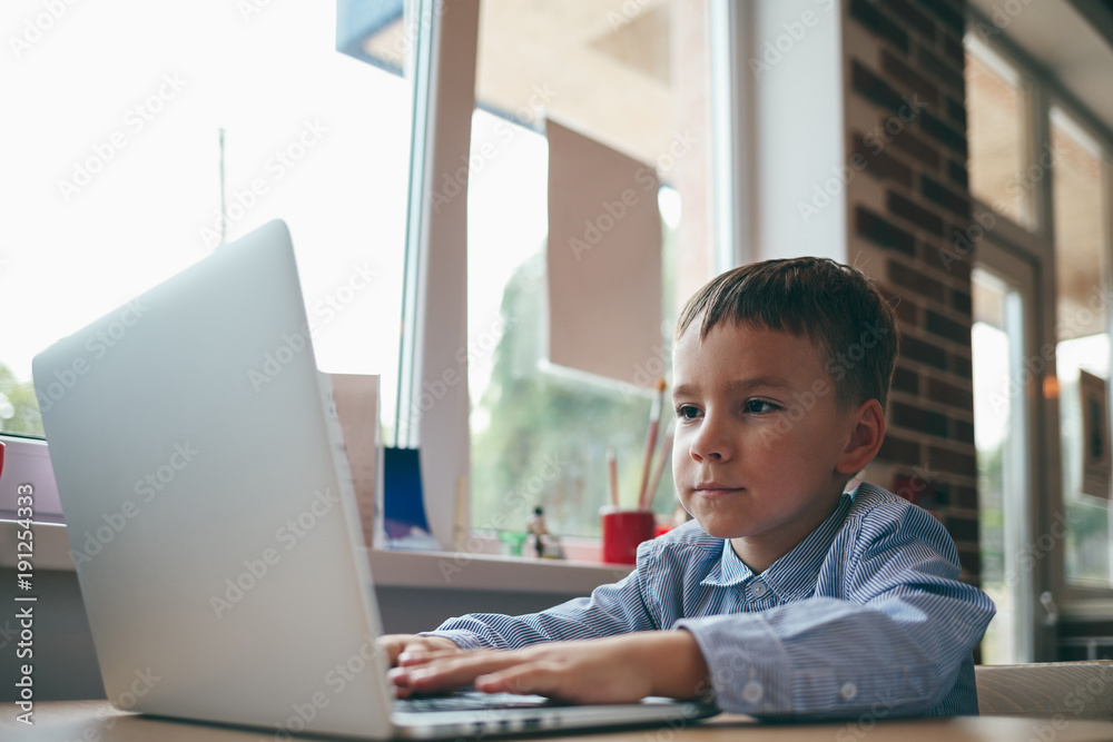 Boy typing on the laptop