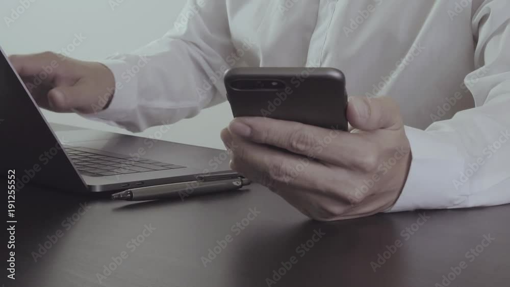 Businessman hand working with mobile phone and laptop in modern office in slow motion Businessman hand working with mobile phone and laptop in modern office in slow motion