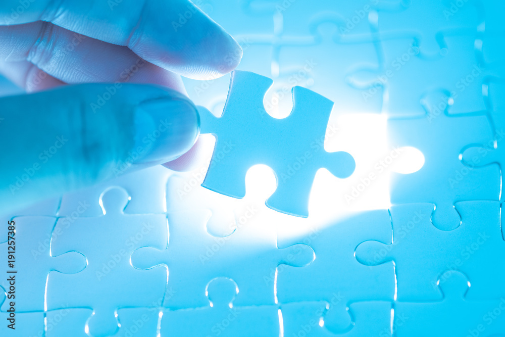 Close up of businessman hands connecting puzzle element and making jigsaw complete Close up of businessman hands connecting puzzle element and making jigsaw complete