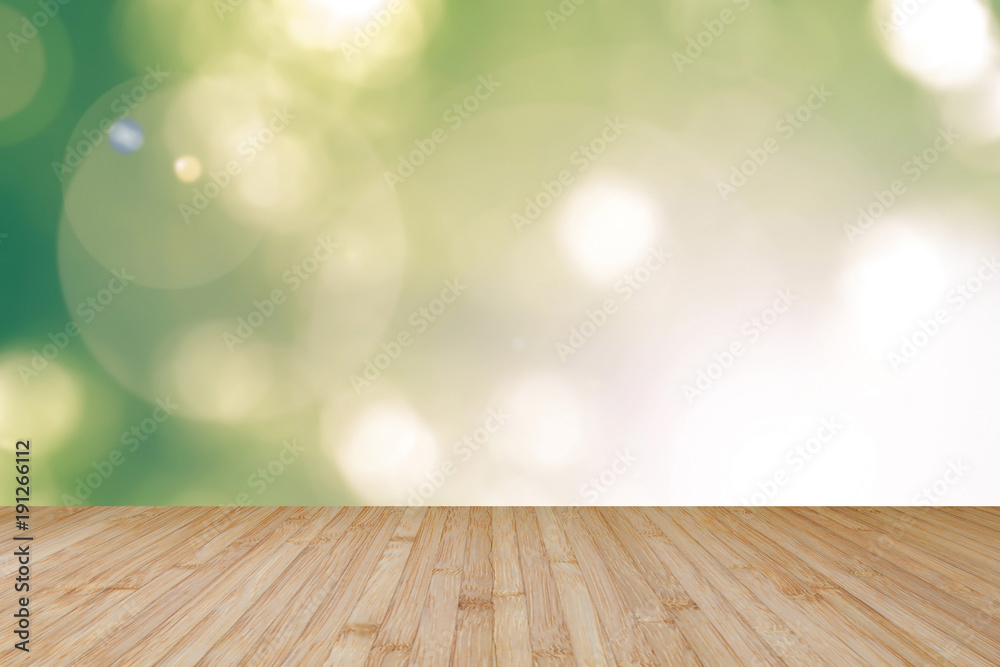 Wooden floor with blurred nature background yellow green tree leaves looking up against sky with sun flare Wooden floor with blurred nature background yellow green tree leaves looking up against sky with sun flare