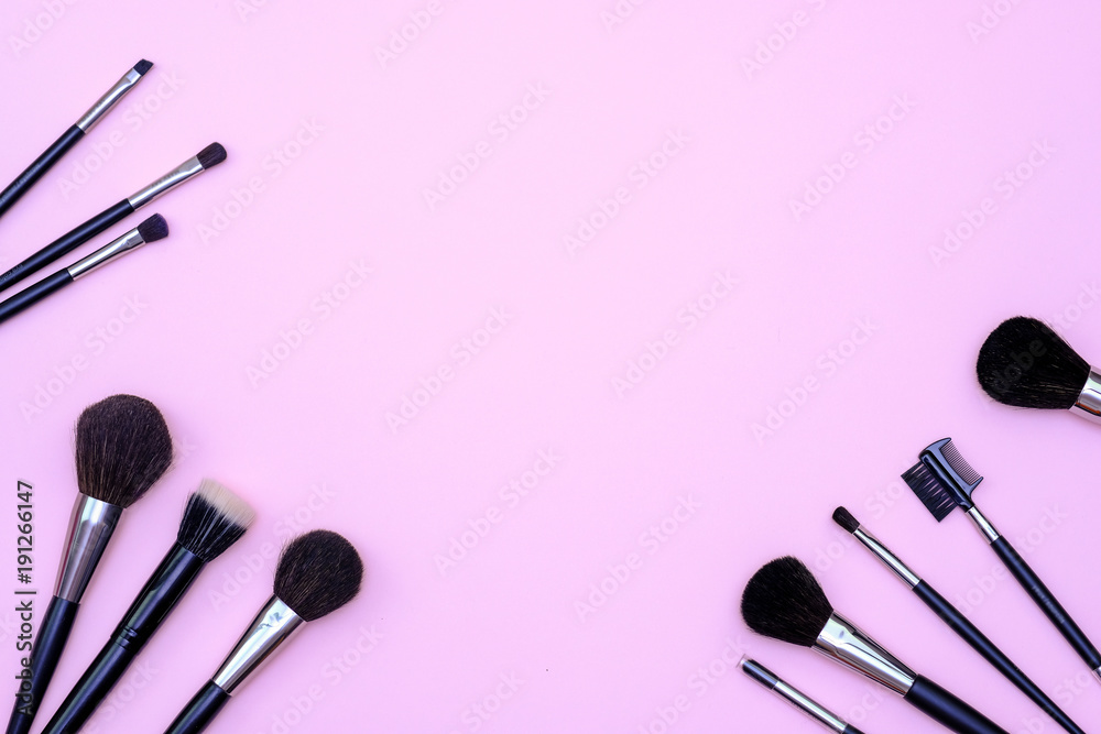 Set of makeup brushes on pink colored composed background. Top view point, flat lay, space for text. Set of makeup brushes on pink colored composed background. Top view point, flat lay, space for text.