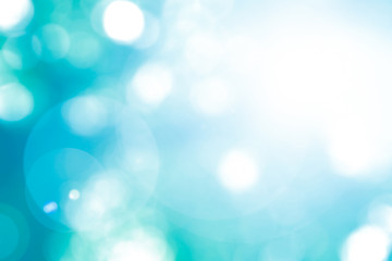 Vintage cool cyan blue green color blurred sky background with nature glowing sun light flare and bokeh