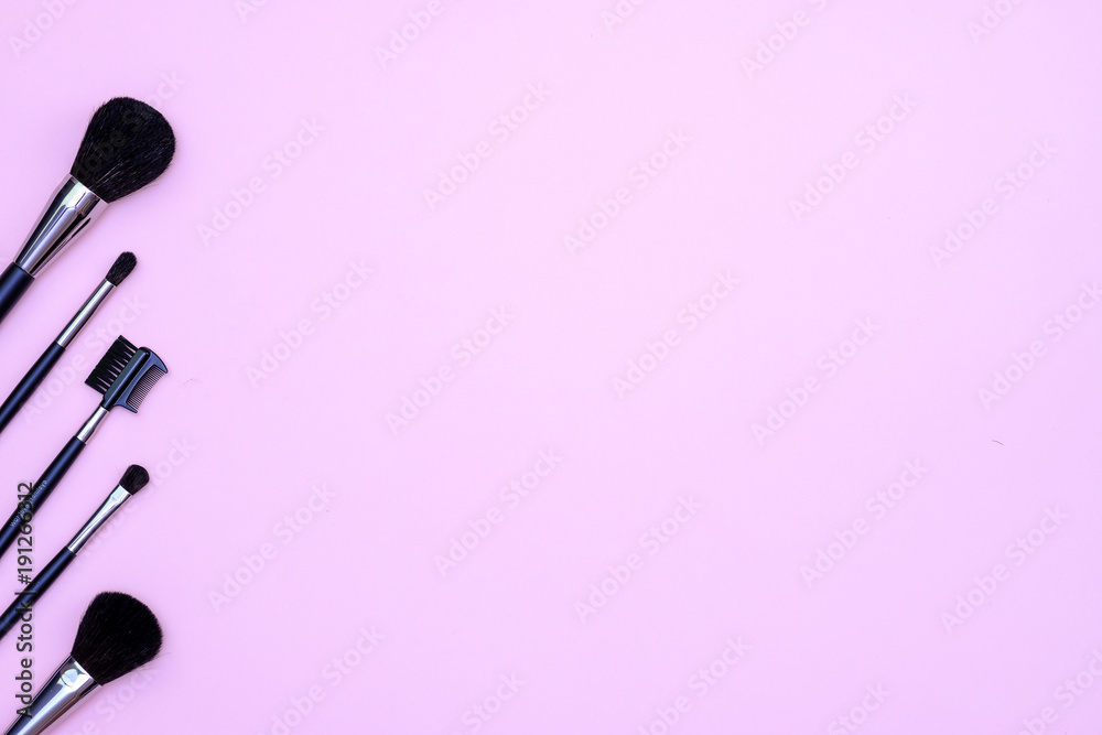 Set of makeup brushes on pink colored composed background. Top view point, flat lay, space for text Set of makeup brushes on pink colored composed background. Top view point, flat lay, space for text