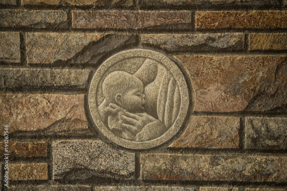 Brick wall with relief mother can child Brick wall with relief mother can child