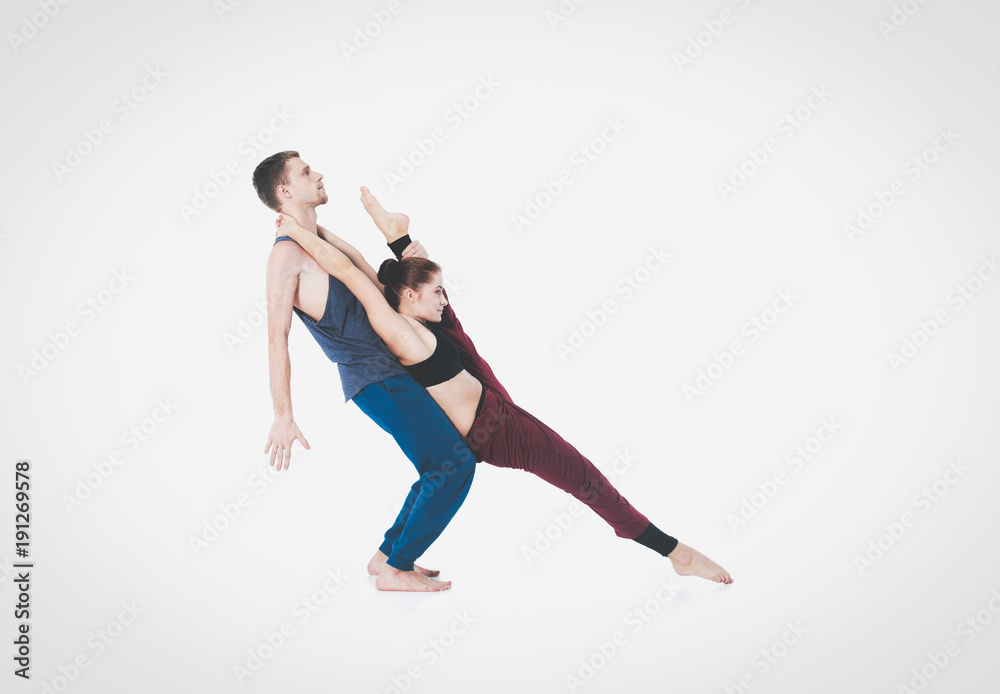 Young athletic couple practicing acroyoga. Balancing in pair