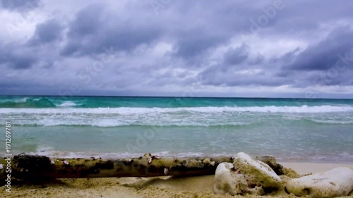 Dark clouds over a wave strewn beach