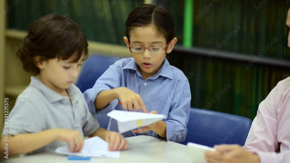 Small children study with teacher. Mixed race boys young children in library with white male teacher. Education concept. Small children study with teacher. Mixed race boys young children in library with white male teacher. Education concept.