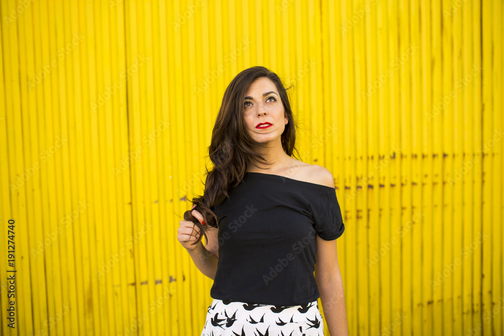 Fototapeta premium Portrait of beautiful girl in urban yellow background