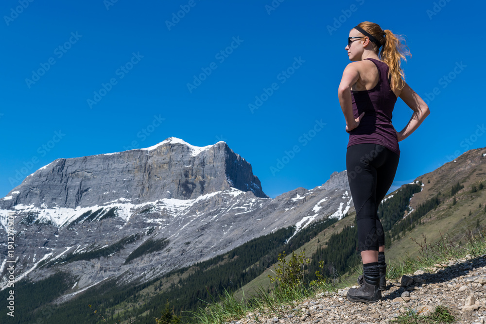 young female woman hiker with active wear looking at mountains