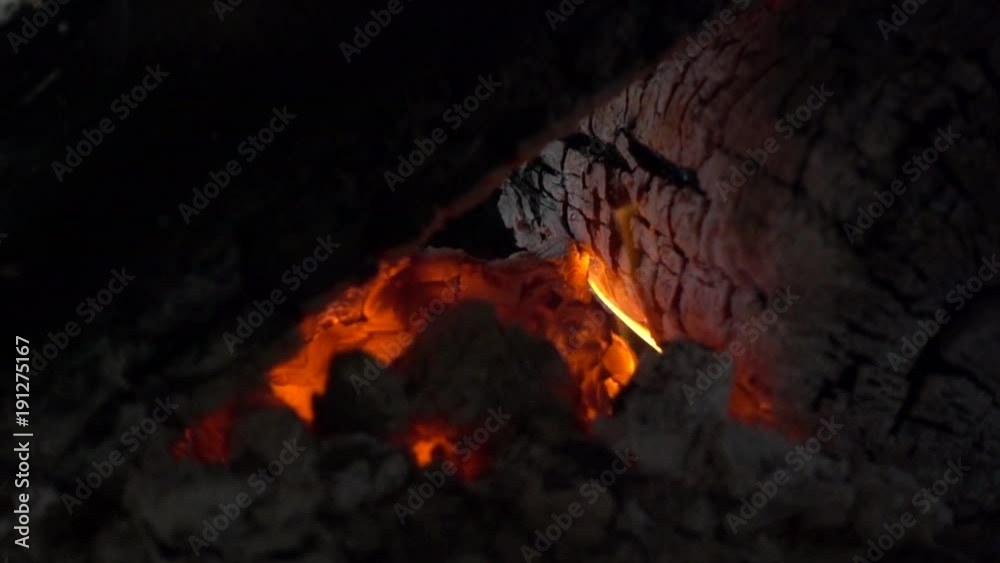 small ember with a little flame slowly burning in fireplace. Big logs that can keep heat for a long time small ember with a little flame slowly burning in fireplace. Big logs that can keep heat for a long time